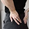 Przestrzenna damska bransoletka NAGANO36 na zdjęciu zachwyca z każdej strony a tu na nadgarstku kobiety stojącej tyłem jaka biżuteria na wiosnę modna modne bransoletki prezent