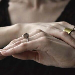 Zachwycający srebrny pierścionek NAGANO 32 z przestrzenną łezką wygląda zachwycająco na palcach kobiety co widać na tym zdjęciu.