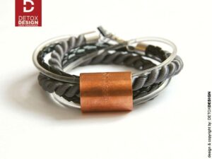 Detoxdesign Na zdjęciu widoczna z przodu jak leży na białym tle nasza autorska bransoletka unisex z tuleją miedzianą zachwyca materiałami i kolorami a dodatkowo zachwyca pomysłowością projektantów bo tą bransoletkę można również nosić jako naszyjnik, bransoletka i naszyjnik OMA PREMIUM18