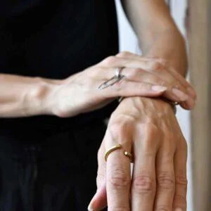 Złoty pierścionek NAGANO38 na zdjęciu to piękny współczesny i jednocześnie minimalistyczny model unisex widoczny na kobiecym palcu z przodu ale równie świetnie wygląda na męskim palcu ponieważ to oryginalna i ponadczasowo modna, minimalistyczna biżuteria unisex.