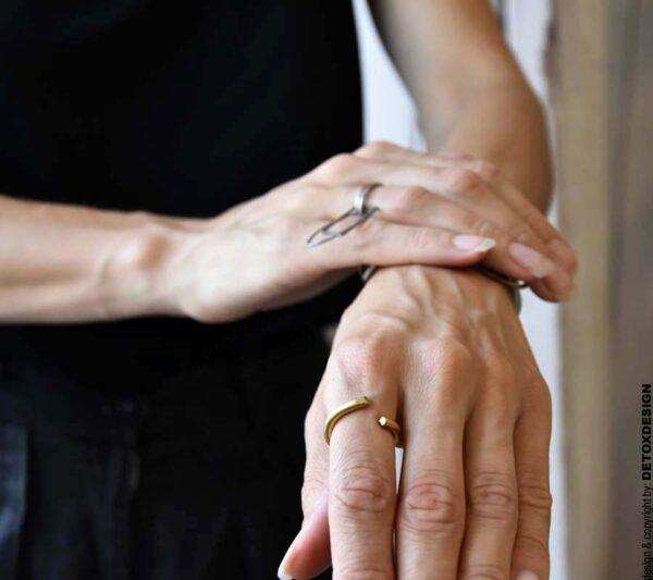 Złoty pierścionek na zdjęciu to piękny współczesny pierścionek i jednocześnie minimalistyczny pierścionek widoczny na kobiecym palcu z przodu.