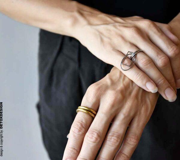 Minimalistyczny pierścionek z mosiądzu widoczny na zdjęciu na kobiecym palcu wygląda super.