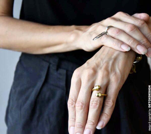 Industrialny złoty pierścionek na zdjęciu wygląda obłędnie na kobiecej dłoni, intryguje i zachwyca jak cała nasza modna biżuteria