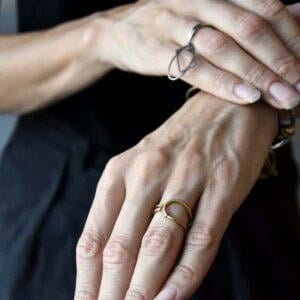 Minimalistyczny złoty pierścionek na zdjęciu na kobiecej dłoni zachwyca bo to też przestrzenny pierścionek i doskonale wygląda z każdej strony.