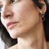 Zobacz nasze autorskie, minimalistyczne kolczyki pokazane na tym zdjęciu jak nosi je kobieta zachwycają i intrygują bo to też cudownie geometryczne kolczyki koła NAGANO48.