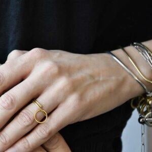 Lekki złoty pierścionek na zdjęciu na palcu zachwyca bo to współczesny pierścionek