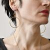 Geometryczne kolczyki noszone przez kobietę na zdjęciu wyglądają obłędnie bo taka jest nasza współczesna, minimalistyczna, szlachetnie prosta, oryginalna i modna biżuteria autorska.