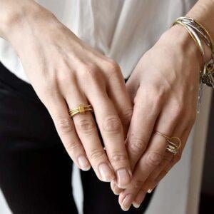 Mosiężny złoty pierścionek 'NAGANO'66 na zdjęciu zachwyca na kobiecym palcu bo to jest nasz oryginalny pierścionek i nasz autorski pierścionek.