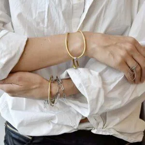 Przestrzenna złota bransoletka NAGANO40 z mosiądzu widoczna na zdjęciu na kobiecym nadgarstku to nasza zachwycająca bransoletka autorska jaka biżuteria na wiosnę modna modne bransoletki prezent