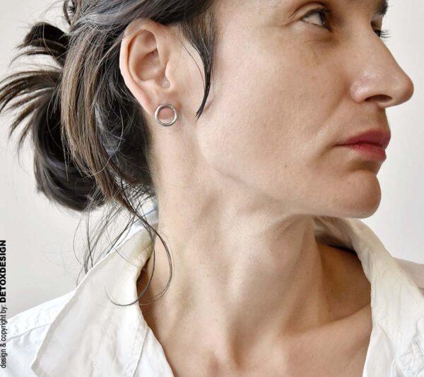Minimalistyczne kolczyki koła na kobiecym uchu widoczne na tym zdjęciu zachwycają bo to szlachetnie proste kolczyki na każdą okazję.