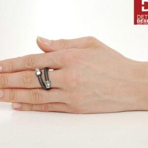 Wzór intrygującego pierścionka unisex wykonanego z najwyższej jakości grafitowego kauczuku i srebrnych zakończeń ze stali nierdzewnej a na zdjęciu ten pierścionek widoczny na kobiecej dłoni to oryginalny pierścionek industrialny KOBRO05