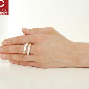 Biały pierścionek industrialny KOBRO07 z mosiądzu i kauczuku widoczny na zdjęciu na kobiecej dłoni zachwyca i zaskakuje bo tak działa cała nasza oryginalna biżuteria autorska.