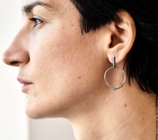 Na zdjęciu profil kobiecej twarzy a na uchu widać nasze lekkie autorskie kolczyki koła NAGANO 09 ze stali chirurgicznej
