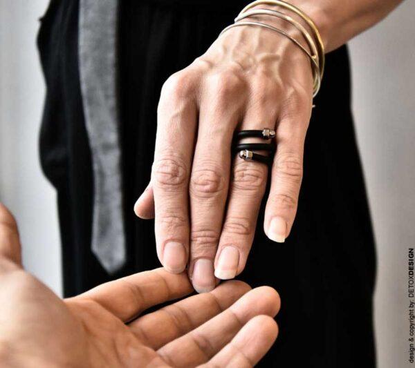 na zdjęciu regulowany pierścionek unisex ma kolor czarny i srebrny a wykonany jest z kauczuku i stali nierdzewnej