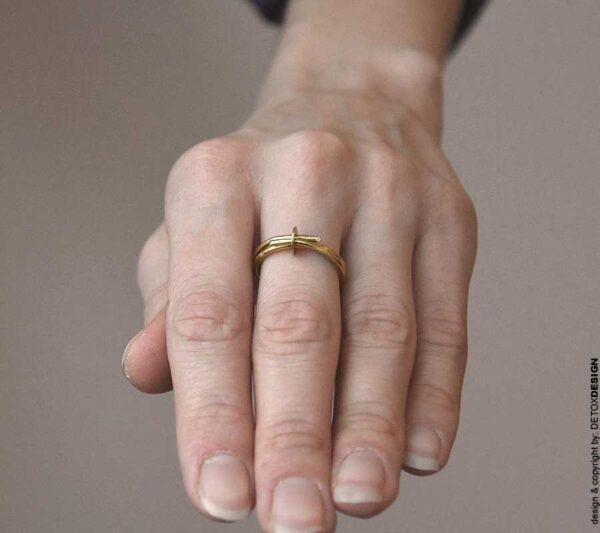 Na zdjęciu delikatny złoty pierścionek NAGANO01 pełen współczesnego i subtelnie technicznego charakteru wykonany z mosiądzu zachwyca na kobiecym palcu.