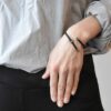 Czarna bransoletka KOBRO04 Subtelna i współczesna czarna bransoletka KOBRO04 na zdjęciu to wzór biżuterii unisex dla kobiet i mężczyzn a na zdjęciu widać bransoletkę z czarnego kauczuku i stali nierdzewnej