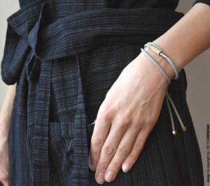 Minimalistyczna bransoletka na zdjęciu to również minimalistyczny naszyjnik bo to bransoletka i naszyjnik w jednym czyli industrialna bransoletka kauczukowa ANDO43 wykonana z kauczuku w kolorze popielatym oraz z mosiądzu