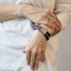 Zachwycająca i intrygująca oraz zaskakująca i współczesna czarna bransoletka OMAPREMIUM06 unisex widoczna na zdjęciu na nadgarstku kobiecym zachwyca a na dodatek można ją nosić również jako naszyjnik.