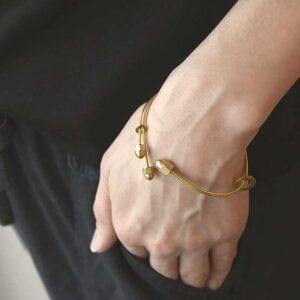 Na zdjęciu nadgarstek kobiecy z bransoletką wykonaną z mosiądzu to złota bransoletka NAGANO08 jaka biżuteria na wiosnę modna bransoletki modne prezent