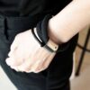 Nasze unikalne bransoletki z tej kolekcji można nosić również jako obłędne i współczesne naszyjniki a na zdjęciu widok naszyjnika w formie bransoletki na kobiecym nadgarstku to czarna bransoletka OMAPREMIUM16