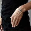 Zdjęcie kobiety noszącej na swoim nadgarstku bransoletkę pełną pięknego minimalizmu oraz oryginalnej i współczesnej elegancji a efekt jest niesamowity a to srebrna bransoletka NAGANO19 jaka biżuteria na wiosnę modna modne bransoletki prezent