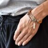 Oryginalna bransoletka z liny IKI26 unisex z liny plecionej w obłędnym pomarańczowym kolorze i stali nierdzewnej a zdjęcie przedstawia widok bransoletki na kobiecym nadgarstku i nasza biżuteria zachwyca i intryguje wszystkich jaka biżuteria na wiosnę modna prezent