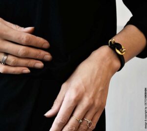 Minimalistyczna czarna bransoletka FUKUI24 na tym zdjęciu wykonana jest z mosiądzu w naturalnym kolorze oraz super kauczuku w kolorze czarnym i zachwyca na kobiecym nadgarstku ale to wzór biżuterii unisex i wygląda obłędnie również noszony przez mężczyzn jaka biżuteria na wiosnę lato modna modne bransoletki prezent