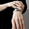regulowana bransoletka unisex w kolorze bieli i szczotkowanej stali nierdzewnej na kobiecym nadgarstku wygląda doskonale.