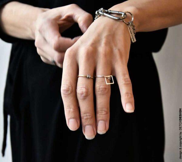 Na tym zdjęciu oryginalna bransoletka i subtelne pierścionki od polskich projektantów biżuterii ozdabiają w niezwykły sposób dłonie kobiety.