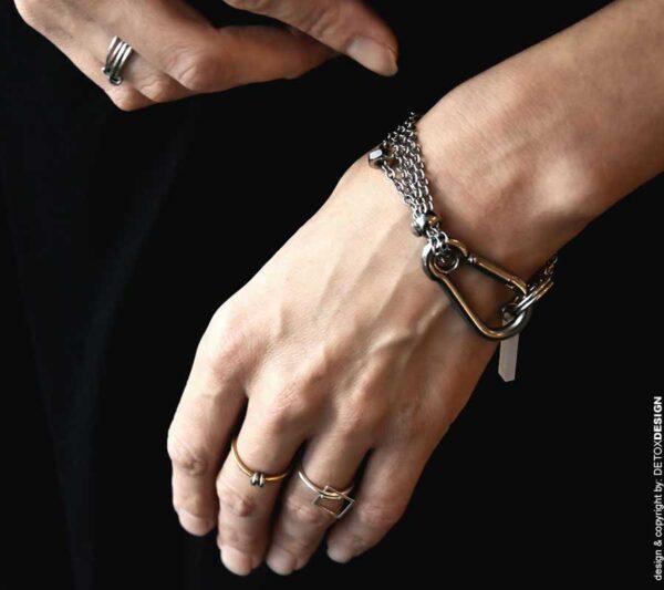 Piękne zdjęcie kobiecych dłoni z naszą autorską i zachwycającą oraz współczesną bransoletką na nadgarstku i naszymi subtelnymi pierścionkami na palcach, srebrna bransoletka AOMORI16 zachwyca jaka biżuteria na wiosnę lato modna na prezent jakie bransoletki najlepsze