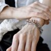 Awangardowy naszyjnik Aomori15 zapleciony jako wielowarstwowa bransoleta z miedzianą spiralą na nadgarstku projektantki DETOXDESIGN.