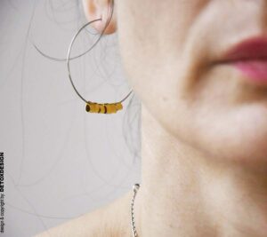 Zbliżenie na detal: Duże kolczyki koła DETOXDESIGN Duże kolczyki koła Nagano83 z mosiężną spiralą w zbliżeniu na uchu projektantki DETOXDESIGN.