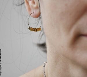 Zbliżenie na detal: Kolczyki Nagano82 DETOXDESIGN Minimalistyczny kolczyk koło Nagano82 z mosiężną spiralą w zbliżeniu na uchu projektantki DETOXDESIGN.