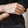 Minimalistyczny pierścionek mosiężny Nagano75 zdobiący dłoń projektantki marki DETOXDESIGN.